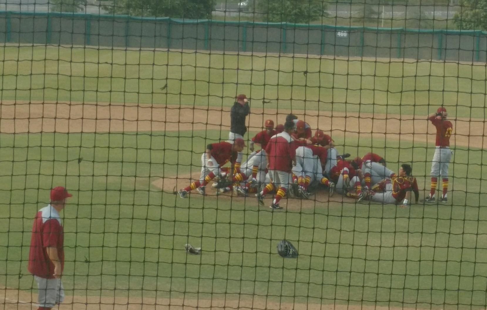 Coach McGee looks on as the Lancers celebrate their first SCC solo baseball title in 50 years.