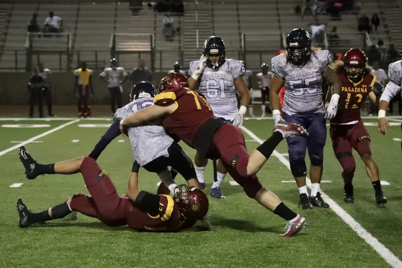 Omar Delgado and Craig Francois bring down a Harbor quarterback during Saturday's Lancers shutout, photo by Michael Watkins.