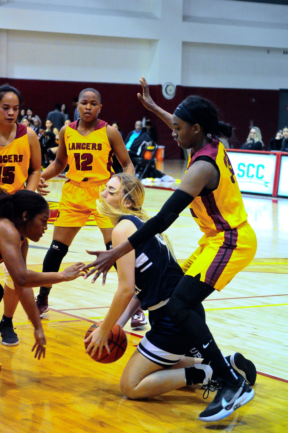 The Lancers swarm around Irvine Valley center Helen Reynolds as Dariel Johnson (far right), Cosette Balmy (lower left), Monet Penson (12) and Merina Latu defend, photo courtesty of Ken McLin.