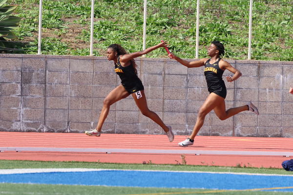 Ireja Lauderdale takes the baton in a relay (photo by Richard Quinton).