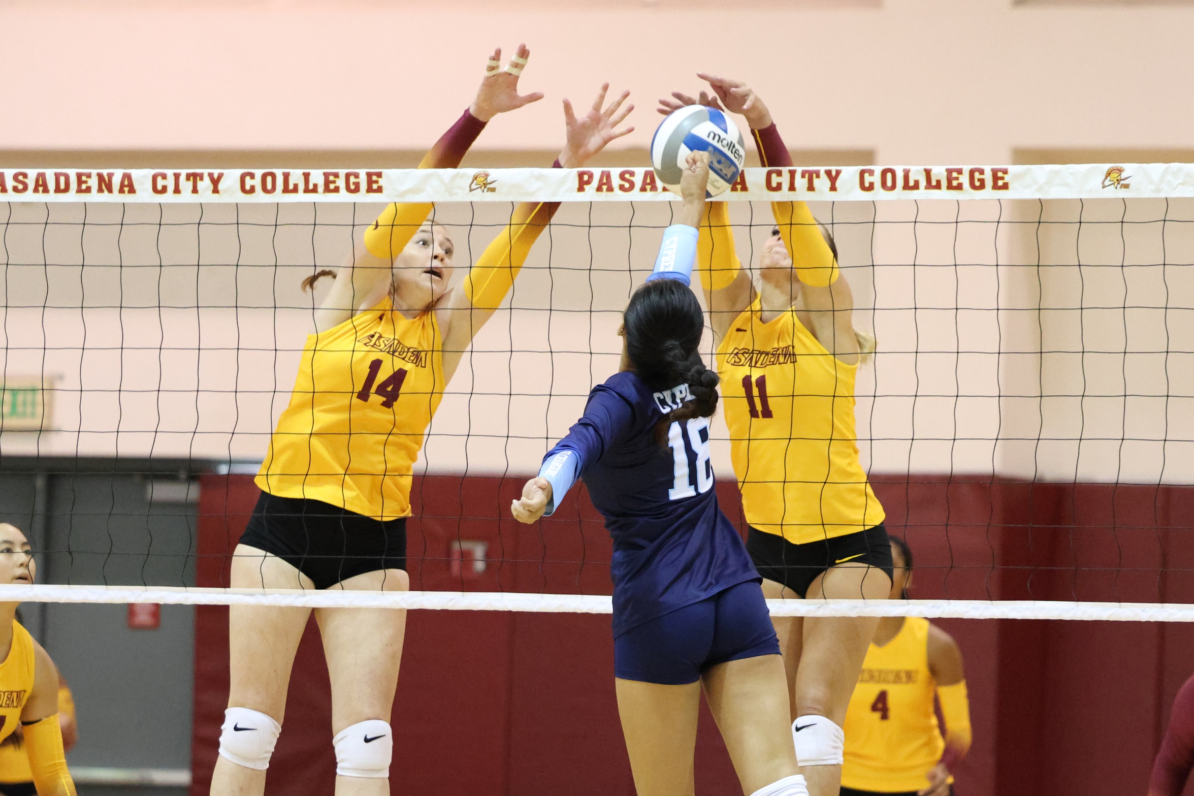 Savannah Curtis and Chayse Hoon put up the block in the season opener v. Cypress (photo by Richard Quinton).